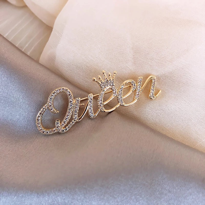 Queen złoty napis z koroną - broszka z cyrkoniami