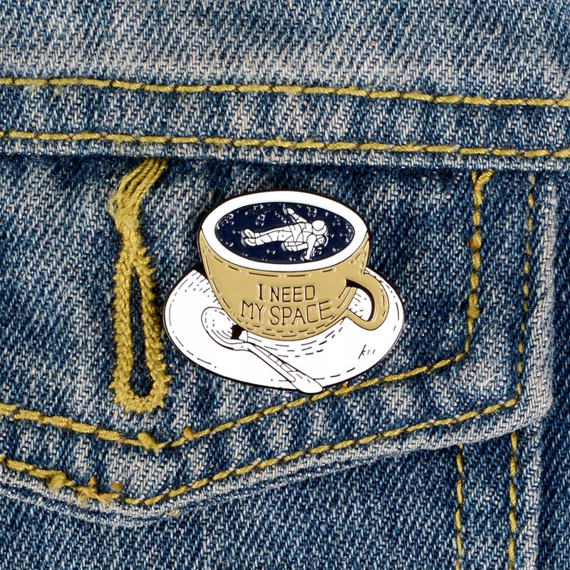 Kubek kawy z kosmonautą - przypinka