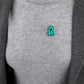 Litera R z otwartą buzią - zielona przypinka